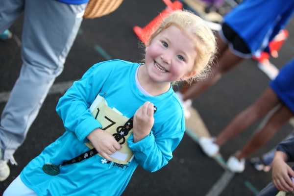 smiling girl with run medal
